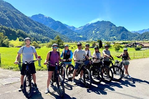 Cycling group photo with mountain valley views on Interlaken E-bike Tour