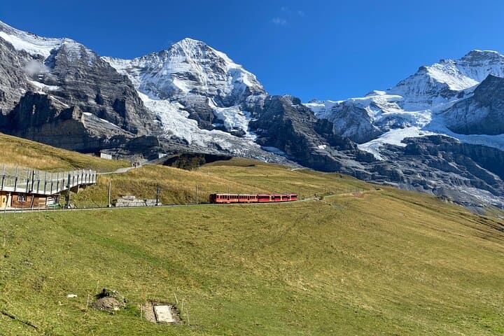 The famous Big 3 Mountains in the back, Eiger, Mönch and Jungfrau. The red train is the Jungfrau Railway, which travels up to Jungfraujoch - Top of Europe