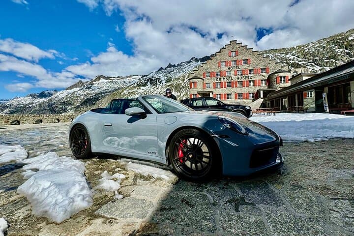 Porsche 911 Convertible parked up in front of Grimsel Hospice during sunny day