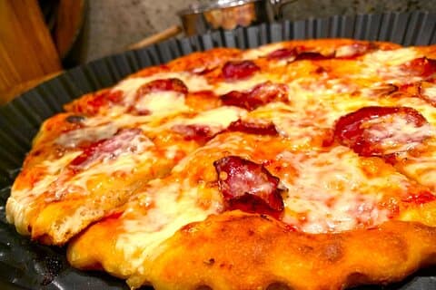 Garnish the pizza with some spicy salami.
