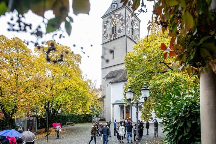 Tour group gathers outside St. Peter Pfarrhaus on this luxury coach tour of Zurich.